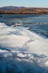 Winter landscape - cracked pieces of ice on the edge of a water dam, frosty sunrise in January, unique structure of ice, winter wonderland, winter in Central Europe, no snow and no people