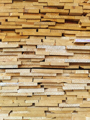 Stacked lumber. Folded wood.Closeup wooden boards.The surface of the end of the board.Lots of planks stacked on top of each other in the warehouse.Lumber for use in construction.