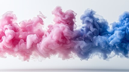 Obraz premium Abstract pink and blue ink clouds swirling together on a white background, creating a soft, dreamy effect