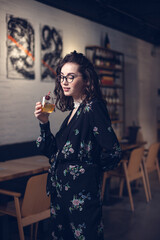 Happy young Asian girl at the bar with her cocktail at night