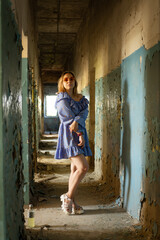 Young Woman in Blue Blouse With Orange Sunglasses Posing in Abandoned Hallway During Daytime