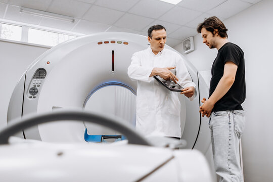 After the MRI procedure, the patient receives doctor's recommendations. MRI scanner capsule. The doctor conducts a tomographic examination and advises a young patient.
