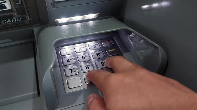 Person Entering PIN on an ATM Machine