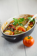 prepared baked zucchini and tomatoes in circles in a ceramic form, vegetable snack