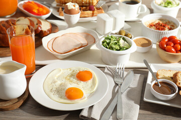 Different meals served for breakfast on wooden table