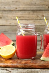 Tasty watermelon drink in mason jars and fresh fruits on wooden table