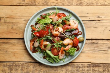 Delicious shrimp salad with vegetables on wooden table, top view