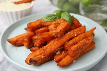 Sweet potato fries and basil on table, closeup