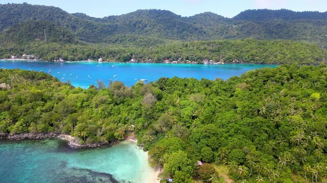 Tropical Beach Nestled by the Vibrant Emerald Green Sea