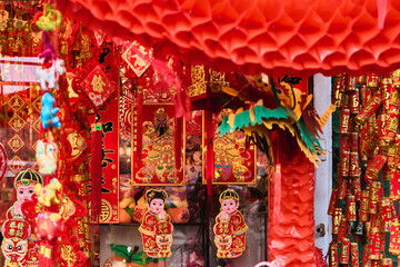 The image shows a collection of red and gold Chinese ornaments hanging abundantly, typical of traditional celebrations like Chinese New Year. The intricate details and vibrant colors capture the essen