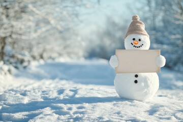 Obraz premium Snowman Holding a Blank Sign in a Snowy Landscape