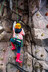 Young girl climbs rock wall