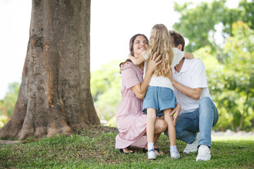 Happy family relaxing together at the park, caucasian family with father, mother, and children walking at the park.