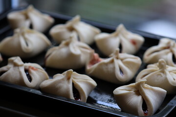 A tray of steaming hot dumplings sits on a table, ready to be served