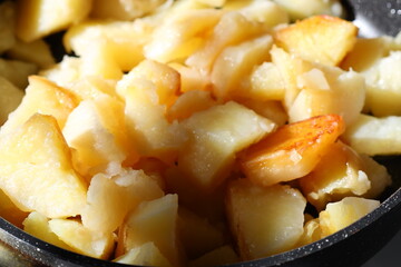 Freshly cut potatoes and carrots in a pan