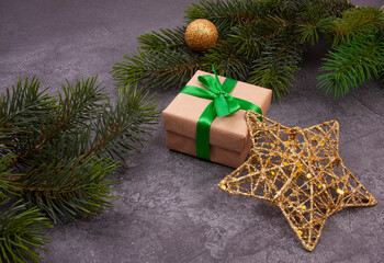 Christmas card with fir branches and handmade gift box. Gift for Christmas and New Year. Golden star and golden ball.