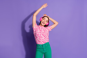 Photo portrait of attractive young woman headphones listen music dance dressed stylish pink clothes isolated on violet color background