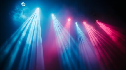 Obraz premium On a concert stage, striking neon blue and pink beams of light cut through a thick mist, enhancing the high-energy atmosphere. The interplay of light and shadow creates a visually compelling 