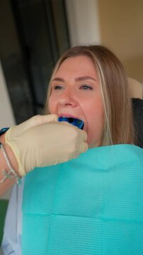 Special Device is Inserted into the Patient Mouth to Take an Impression of Her Dental Bite. Concept of Modern Medicine and Health. Vertical Video. Slow Motion.