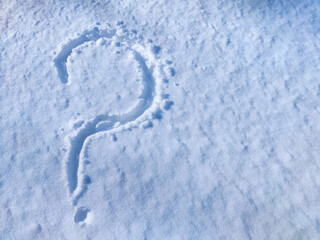 Question mark imprinted in fresh snow on a bright winter day