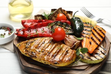 Delicious grilled vegetables and chicken breast on table, closeup