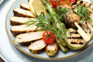 Delicious grilled vegetables and cut chicken meat on table, closeup