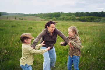 mother breaks up the children who are fighting in the rain in the field