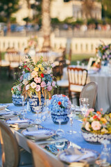 Outdoor Wedding Reception with Brown Chairs and Decorated Tables on a Green Lawn in a Scenic Nature Setting