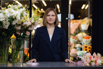 Small business owner, young woman florist making bouquet working at flower shop