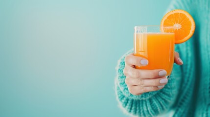 A person holding a glass of freshly squeezed orange juice, highlighting the importance of starting the day with a healthy drink.