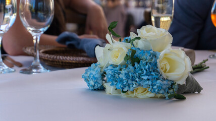 White roses centerpiece against blurred party background during daytime