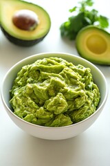 Obraz premium This image features a bowl filled with fresh avocado guacamole, which is often served as a dip or topping for various dishes. The ingredients are visibly prepared and ready to eat.