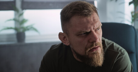 Fototapeta premium Close up of depressed military man with contusion or PTSD crying during rehabilitation after war or counseling session. Soldier talks to psychotherapist or psychologist. Post traumatic stress disorder