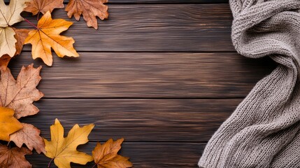 Obraz premium A rustic wooden surface layered with colorful fall leaves, a woolen scarf, and soft ambient lighting, creating the perfect autumnal vibe for branding.
