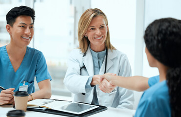 Meeting, medical and handshake with people in hospital boardroom for deal, planning or research. Interview, hiring and onboarding with confident medicine team shaking hands in clinic for healthcare