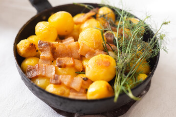 Delicious freshly cooked fried new potatoes with bacon served in a frying pan