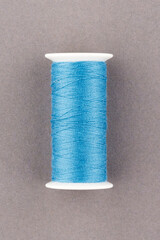 Blue thread spool close-up macro flat lay top view.