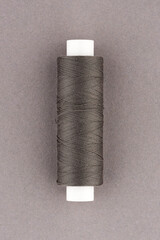 Black thread spool close-up macro flat lay top view.