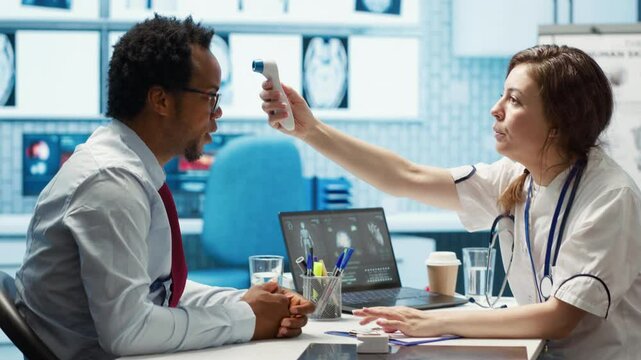 Medic expert uses a thermometer to find the right diagnostic and symptoms, showcasing modern healthcare practices to support patients on medical insurance services. Fever measurements. Camera A.