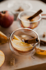 apple tea in glass cups with red apple slices and cinnamon stick, autumn tea, autumn drink, tea with brown cane sugar, autumn composition, fruit tea