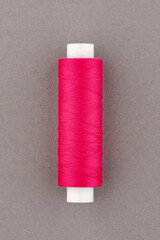 Pink thread spool close-up macro flat lay top view.