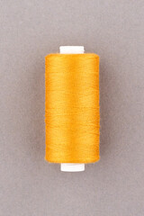 Orange thread spool close-up macro flat lay top view