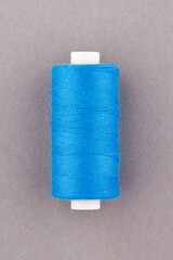 Blue thread spool close-up macro flat lay top view.
