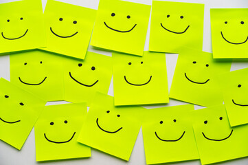 Colored sheets of paper, with smiley faces drawn on them, inclusion, harmony and welcome.
