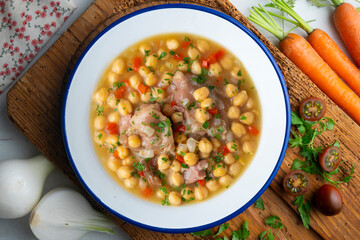 Chickpea stew with pig trotters. Top view table with  decorations.