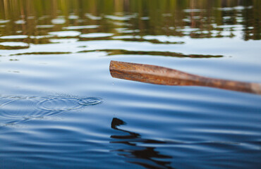 Rowing at a lake. Droplets breaking the surface of the water.