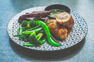 Roasted Chicken Roulade Roasted sweet potatoes, steamed green vegetables, chimichurri sauce .