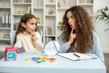 Speech therapist and her patient looking involved while doing exercises