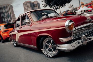 A pristine example of vintage automotive design, this car&rsquo;s maroon body shines under the light. Its classic wheels and sleek lines reflect a timeless aesthetic loved by car enthusiasts.