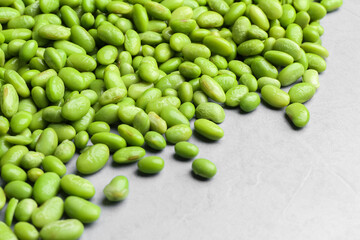 Fresh edamame soybeans on grey textured table, closeup